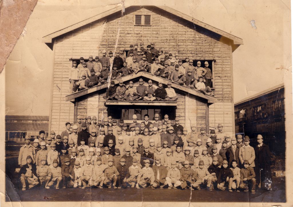 圖三　「台灣少年工」在宿舍前的合影。1942年10月起，台灣總督府以海軍軍屬名義，招募了八千多名青少年到日本神奈川縣高座郡海軍航空技術廠相模野出張所（後改名高座海軍工廠），學習製造、維修軍用飛機的工作。這些台灣青少年多未滿20歲，故被稱為「台灣少年工」，他們在太平洋戰爭中製造了上百架飛機。（來源：維基共享資源，公有領域）