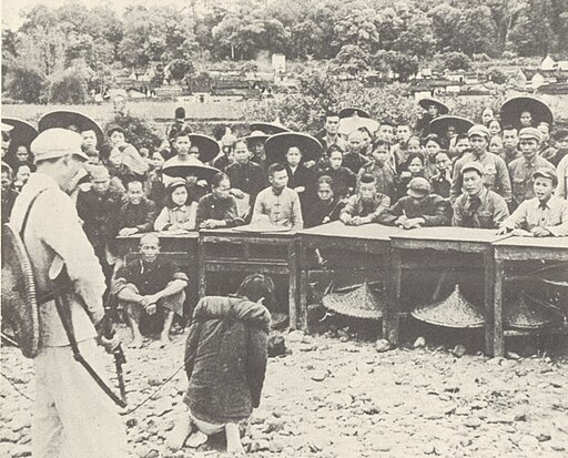 圖六　1952年7月，廣東一名農民被指控是「剝削人民」的「地主」，共幹將他押解到群眾大會上受公審。于茄輕的母親在山東老家，也在鬥爭大會時受到拷問和羞辱。（來源：維基共享資源，公有領域）